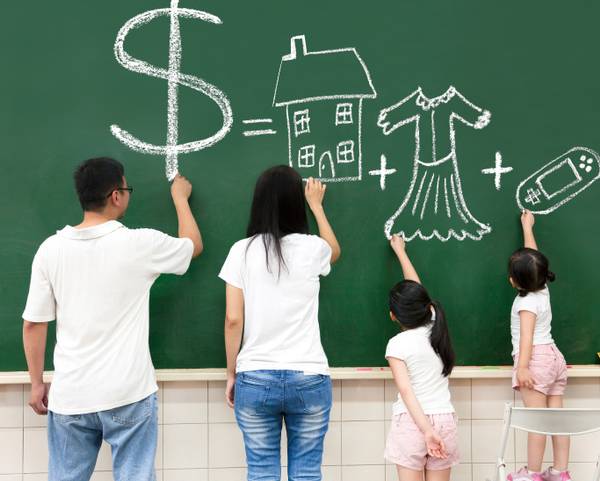 family at chalkboard writing about finances