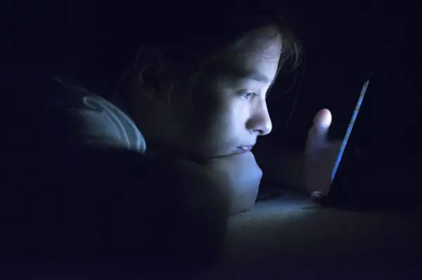 teenager on phone at night