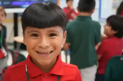 A first grade student is seen smiling the day of JA High School Heroes at Jupiter Elementary School.